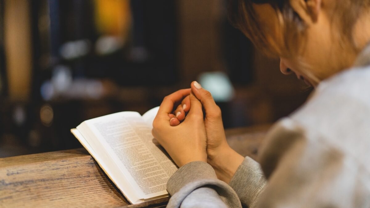 Mulher lendo a Bíblia na Igreja