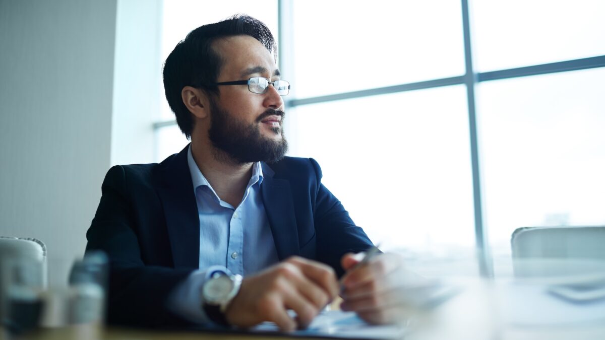 Pensive businessman looking in the office window